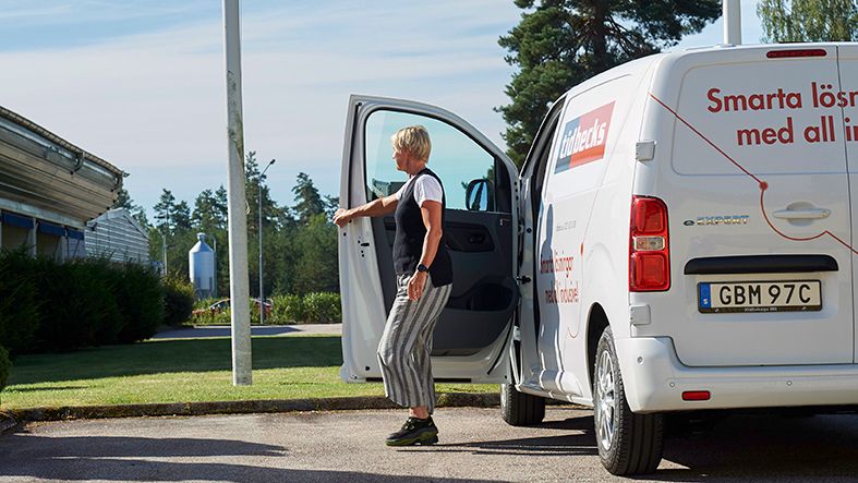 Person stänger dörren på Tidbecks bil som står parkerad utanför kontoret