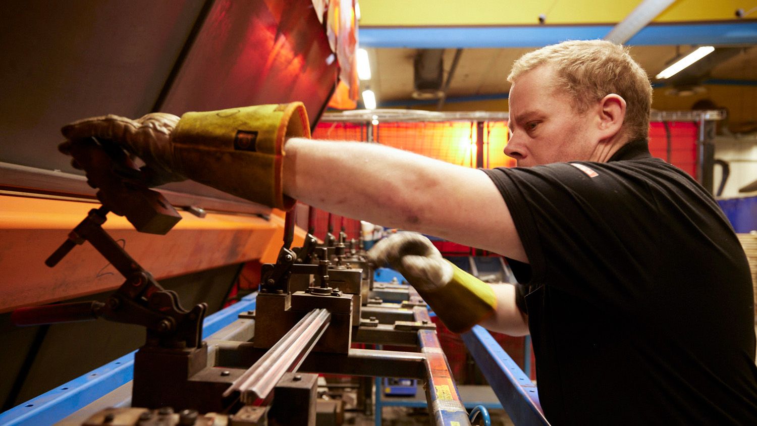 En medarbetare står och arbetar vid en bockmaskin