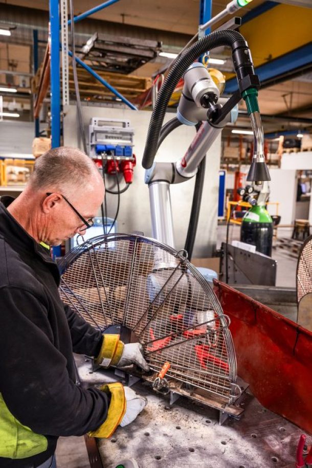 En medarbetare står vid en arbetsbänk och tillverkar ett skydd