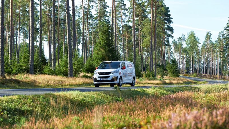 Tidbecks bil kommer körandes på en väg i skogen