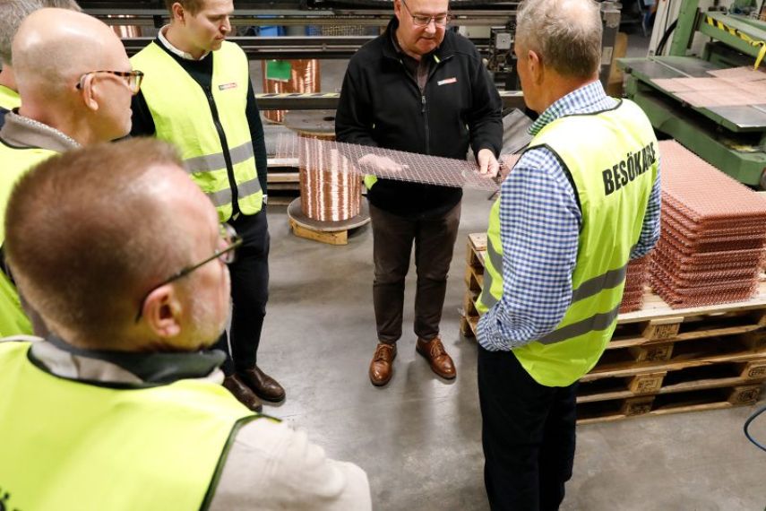 VD Sven-Olov visar upp ett krenelerat galler för ett gäng besökare