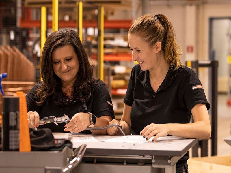 Två tjejer står och pratar om produkt