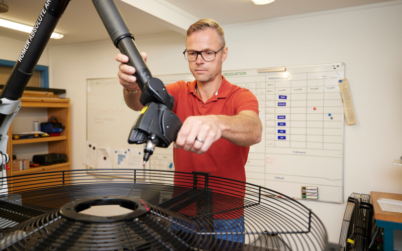 En medarbetare kontrollerar ett skydd med hjälp av en mätmaskin