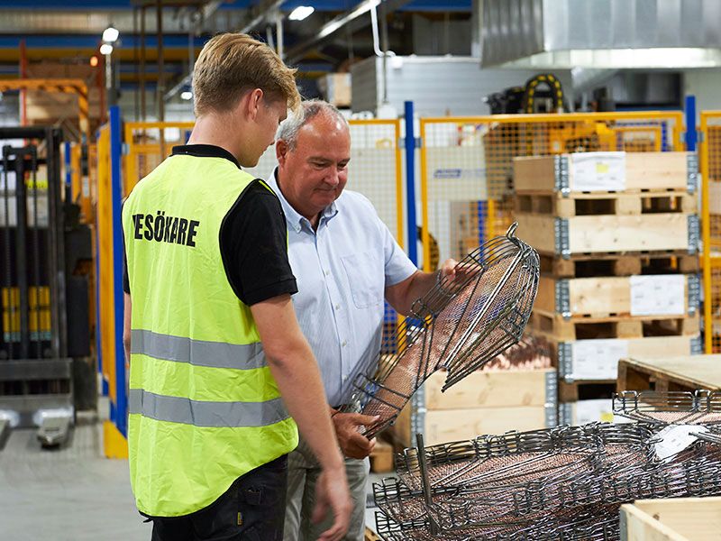 Sven-Olov står i produkt och visar en av produkterna för en yngre besökare