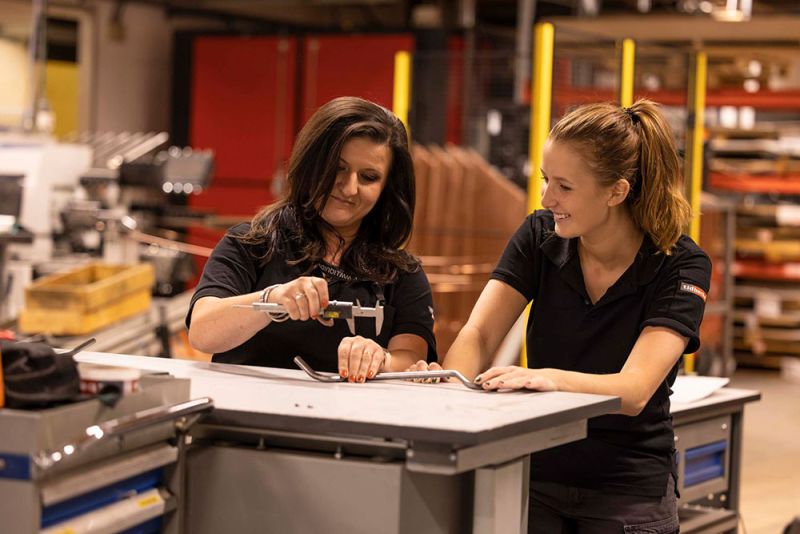 Två tjejer står och pratar och diskuterar en produkt