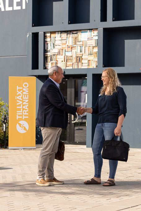 VD Sven-Olov skakar hand med en kvinna framöver en Tillväxt Tranemo roll-up