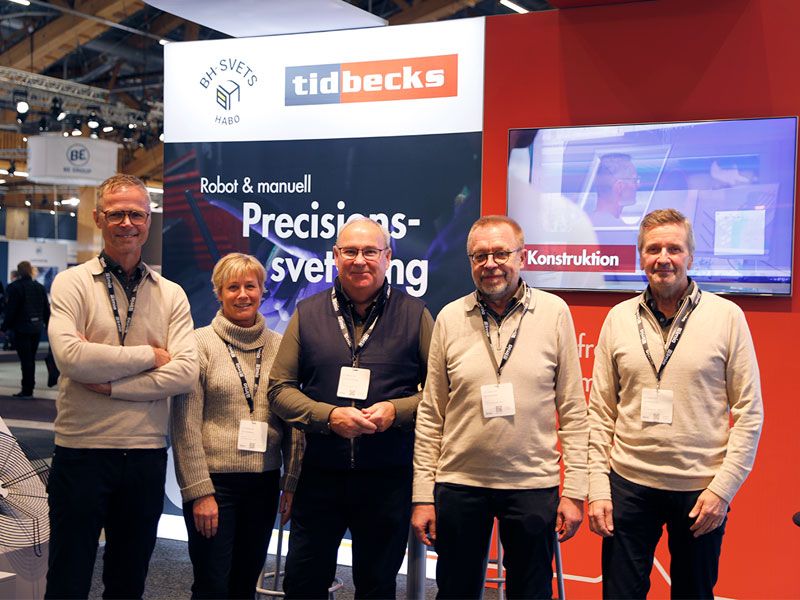 fem personer framför monter