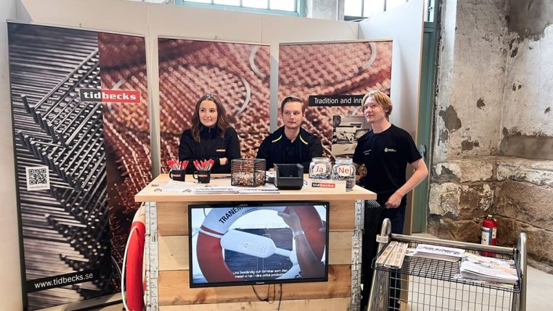 Tidbecks monter med tre gymnasieelever på en rekryteringsmässa