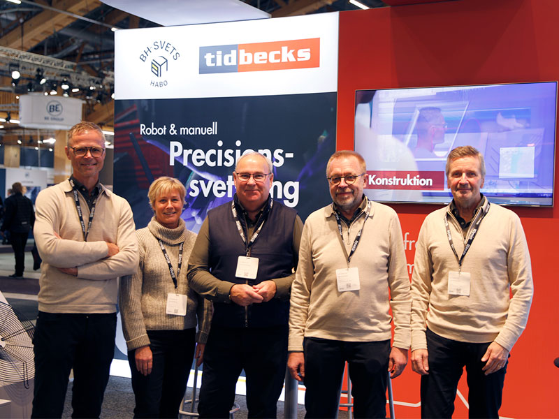 fem personer framför monter