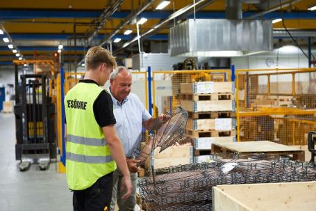 VD Sven-Olov visar upp en tillverkad produkt för en besökare